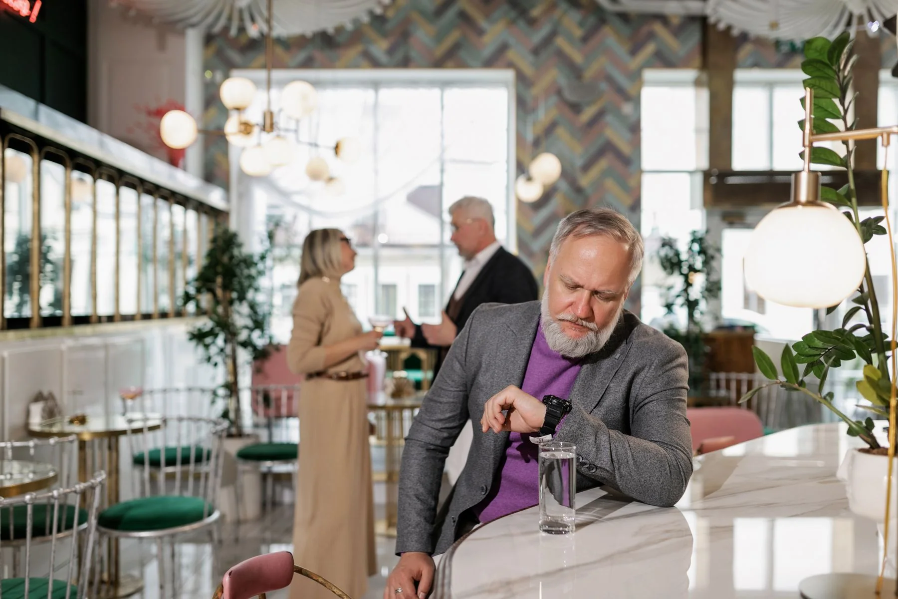 Un client assis dans un café regarde sa montre